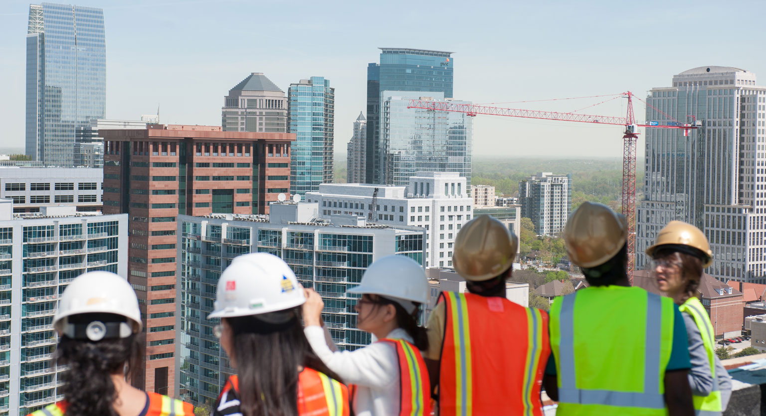 Students looking at a city view from the rooftop of a construction site. 