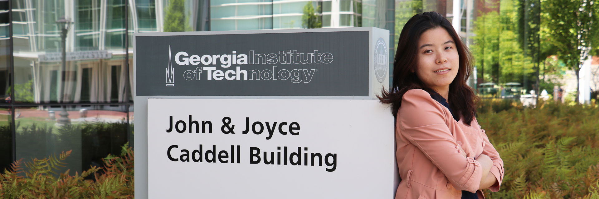 Femail student standing with back against the Joyn and Joyce Caddell Building signage. 