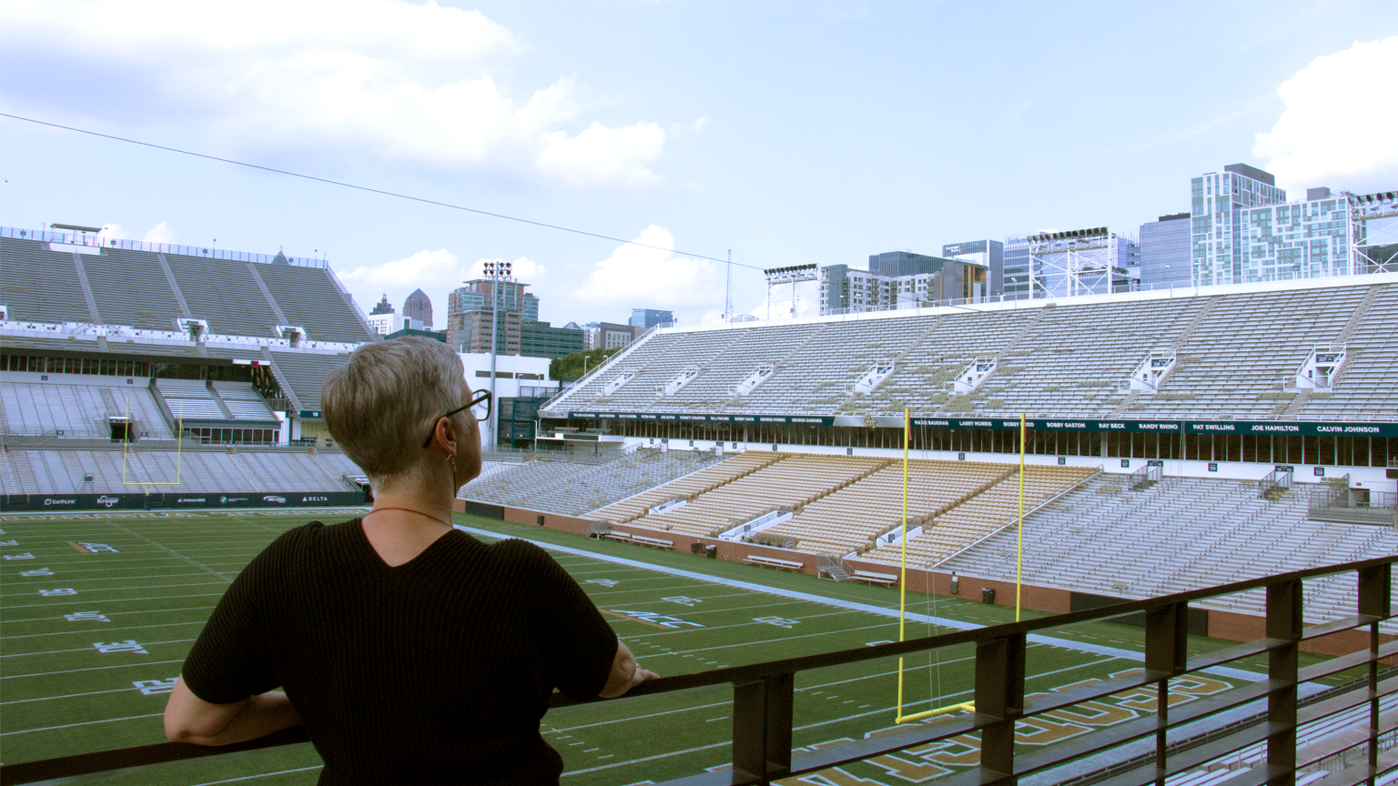 Michelle Rinehart facing the Bobby Dodd Stadium football field and Atlanta skyline.