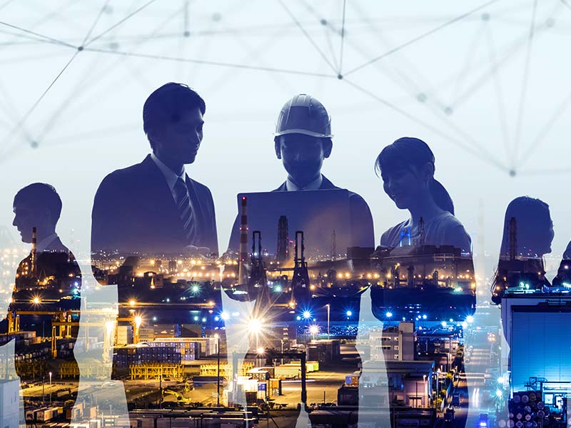 A city skyline superimposed against construction managers against an overlay of data.